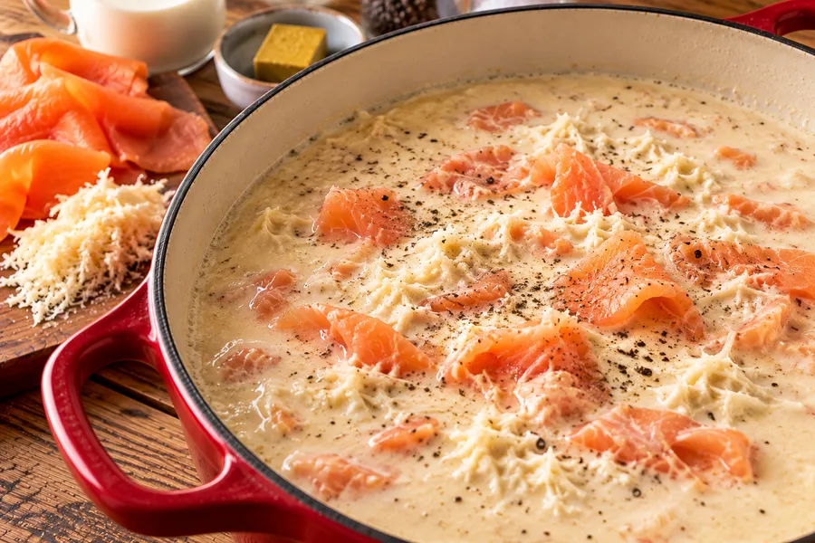 Mierikswortelsoep met gerookte zalm tijdens het maken, van dichtbij.